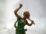 une figurine représentant une femme tenant une trompette à la main