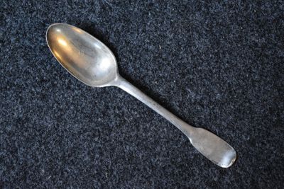 a spoon that is laying on a black surface