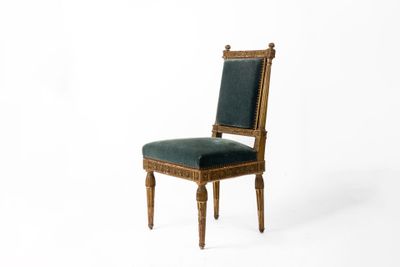 une image représentant une chaise en bois dont l'assise est recouverte d'un tissu vert