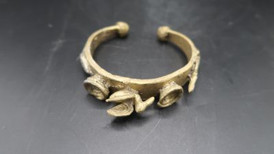 a close up of a gold bracelet on a table