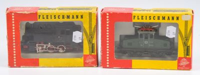 deux boîtes contenant des trains miniatures, posées sur une surface blanche