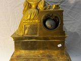 a gold statue of a woman sitting on a table