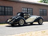 a black and white car parked in front of a brick building