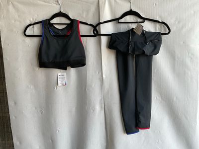 two pieces of clothing hanging on a hanger next to a white sheet