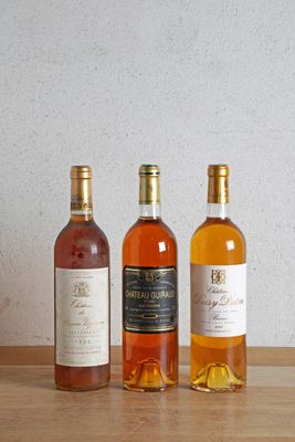 trois bouteilles de vin posées sur une table, l'une à côté de l'autre