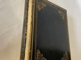 un vieux livre à la couverture noire posé sur une table