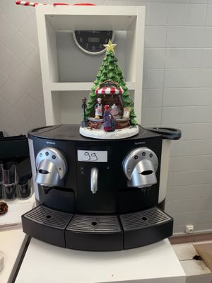 une machine à café sur laquelle est posé un sapin de Noël