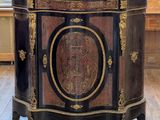 un meuble noir et doré dans une pièce dotée d'une grande fenêtre