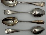 four spoons are lined up in a row on a white surface