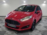 une Ford Fiesta rouge garée dans un garage au sol carrelé