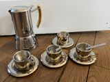 quatre tasses à café et une cafetière par terre