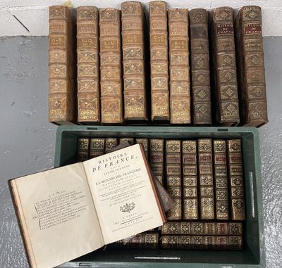 un livre ouvert posé sur une boîte verte à côté d'une pile de livres