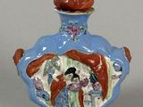 a small blue vase with a painting on it