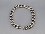 un bracelet en argent avec une grosse chaîne à maillons sur fond gris