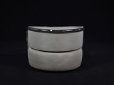 two white stools stacked on top of each other on a black background
