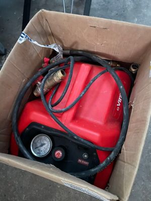 une boîte contenant un bidon d'essence rouge et un tuyau