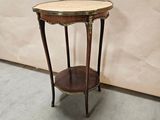a small round table with a marble top on the floor