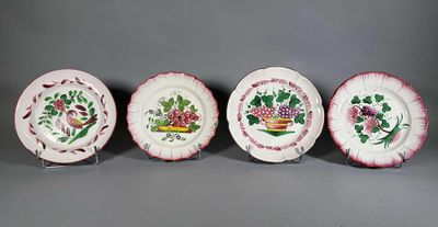 quatre assiettes ornées de fleurs et de feuilles, posées sur une table