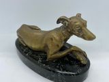 statue of a greyhound dog on a black marble base on a white background