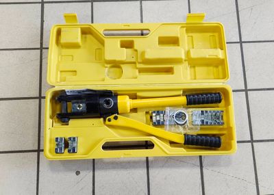 a yellow tool box with tools in it on a tiled floor