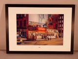 framed photograph of a picture of a city street with people walking by