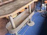 des tables et des tabourets dans une pièce au sol bleu, avec un bar