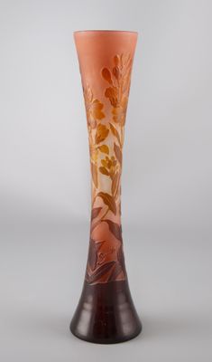 un vase orange posé sur une table près d'un mur blanc
