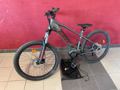 a bike that is sitting on the floor in front of a red wall