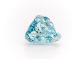 a close up of a blue diamond on a white surface
