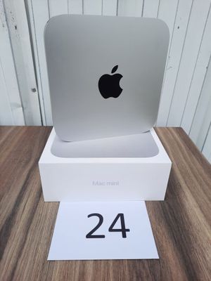 an apple computer sitting on top of a white box on a wooden table