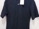 a black t - shirt hanging on a hanger on a wall