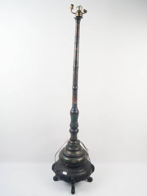 une lampe à l'ancienne avec un pied en métal et un abat-jour en verre