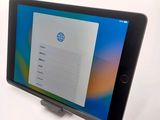 the tablet is sitting on top of the stand on the table