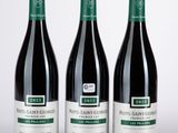 trois bouteilles de vin posées sur une table l'une à côté de l'autre