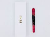a red pen sitting next to a white box on a table