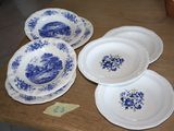 four plates on the table with blue flowers on them