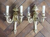 two wall sconces that are on a wooden floor