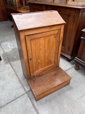 une petite armoire en bois posée sur le trottoir