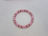 a pink bracelet with a green and red stripe around it