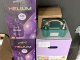 two boxes of helium on the floor next to a teddy bear