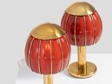 pair of red and gold table lamps on a white surface