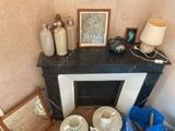 a fire place in the corner of a room with many items on it