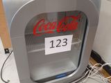 un distributeur de Coca-Cola sur lequel est apposée une étiquette indiquant le prix