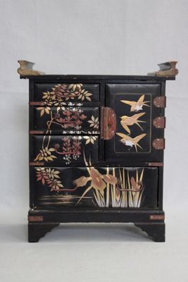 une armoire noire ornée d'un motif représentant un oiseau