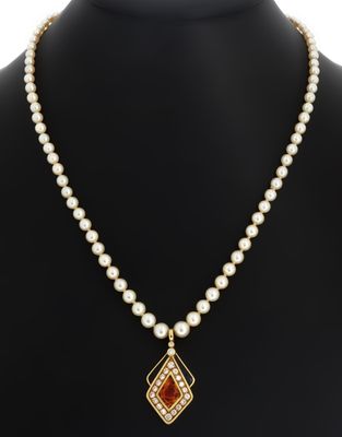 un collier orné de perles et d'un pendentif en pierre rouge