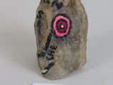 a small rock with a face painted on it