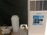 a small air conditioner sitting on a table next to a cup of coffee