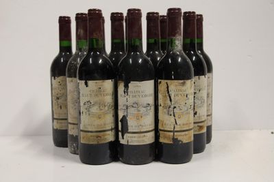 six bottles of wine are lined up in a row on a white surface