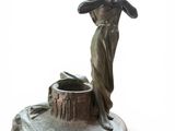 statue of a woman holding a bird on a pedestal