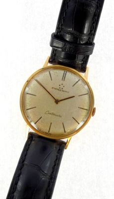 an image of a gold watch with a black strap
